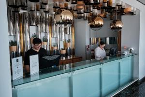 twee mannen aan een balie in een kamer bij Hotel Praia Marina by RIDAN Hotels in Praia da Vitória