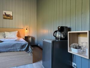 a bedroom with a bed and a blender on a refrigerator at Morgedal Gjestehus in Morgedal