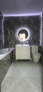 a bathroom with a sink and a toilet and a mirror at Квартира со всеми удобствами in Osh +7 photos