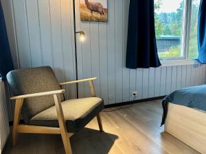 a bedroom with a chair and a bed and a window at Morgedal Gjestehus in Morgedal
