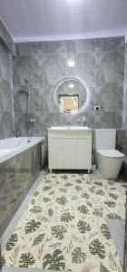 La salle de bains est pourvue d'une baignoire, d'un lavabo et d'un miroir. dans l'établissement Квартира со всеми удобствами, à Och
