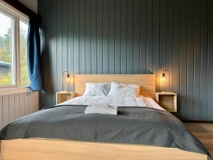 a bedroom with a large bed with two lamps at Morgedal Gjestehus in Morgedal