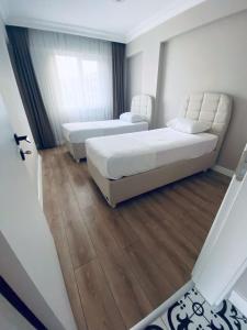2 camas en una habitación con suelo de madera en The Rooms Boutique Otel en Kumbağ