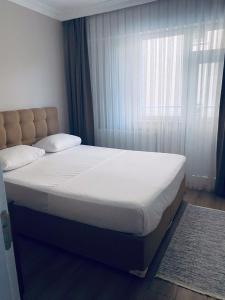 uma cama num quarto com uma grande janela em The Rooms Boutique Otel em Kumbağ