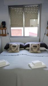 een slaapkamer met een bed met 2 kussens en een raam bij Plein centre, proche plage et port, garage in Águilas