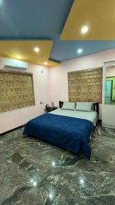 1 dormitorio con 1 cama azul grande en una habitación en Welldone Wayanad Holidays en Sultans Battery
