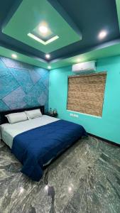 1 dormitorio con 1 cama con pared azul en Welldone Wayanad Holidays en Sultans Battery