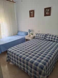 a bedroom with two beds and a night stand with a bedskirts at Bienvenido a tu habitacion in Málaga
