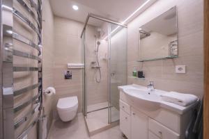 a bathroom with a shower and a sink and a toilet at Gynėjų Self Check-in Apartments - Lollo Stay in Vilnius +66 photos