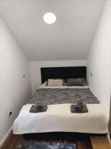 une chambre avec un grand lit avec une tête de lit noire dans l'établissement July Holiday House, à Dugo Selo