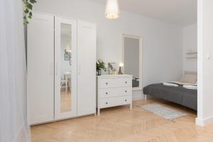 een slaapkamer met een bed, een dressoir en een spiegel bij Spacious & Comfortable Studio Apartament Rajska with Balcony by Renters in Łódź