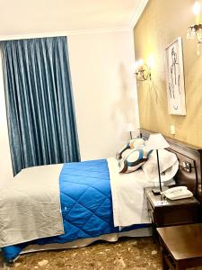 a hotel room with a bed with a blue blanket at Hostal Sonsoles Madrid-Centro in Madrid