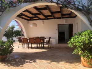 a patio with a table and chairs under an archway at Chalet individual con jardín en Puerto Rey, Vera in Los Amarguillos
