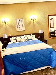 a bedroom with a blue bed with two lights on the wall at Hostal Sonsoles Madrid-Centro in Madrid