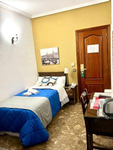 a hotel room with two beds and a desk at Hostal Sonsoles Madrid-Centro in Madrid