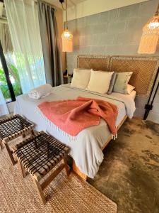 Un dormitorio con una cama con una manta. en CASAS LEON Casita de playa #2 en Santa Bárbara de Samaná