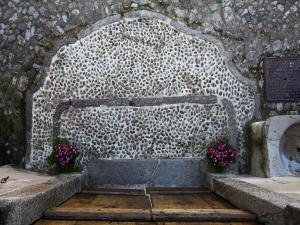 a stone monument with flowers on top of it at B&B Contrada Lunga in Abbadia Lariana