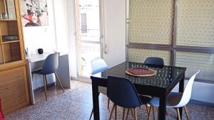 een eetkamer met een zwarte tafel en stoelen bij Plein centre, proche plage et port, garage in Águilas