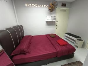 a bedroom with a large bed with a red blanket at ROOMSTAY NIMAZA Bilik 2 in Marang