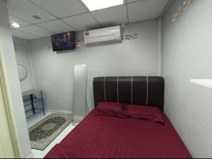 1 dormitorio con 1 cama con manta roja en ROOMSTAY NIMAZA Bilik 2, en Marang