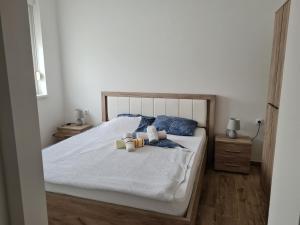 um quarto com uma cama branca e 2 almofadas em KARIBO apartman 3 em Sombor