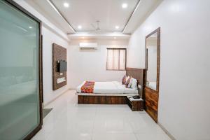 um quarto com uma cama e um espelho em FabHotel Krishna Inn em Bhiwandi