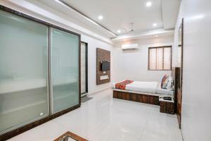 um quarto com uma cama e uma porta de vidro deslizante em FabHotel Krishna Inn em Bhiwandi