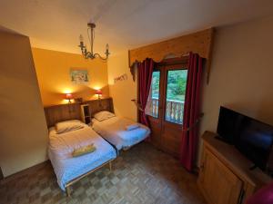 una camera con 2 letti singoli e una TV di le jardin de talèfre a Chamonix-Mont-Blanc
