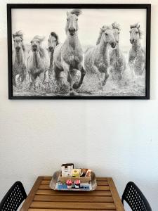 a painting of horses running on a wall at Studio vue port, parking privé, terrasse, clim in Le Grau-du-Roi