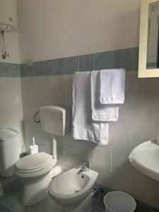 a bathroom with a toilet and a sink and towels at Isola delle Femmine Apartment in Capaci in Capaci