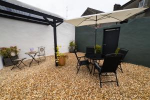 a patio with a table and chairs and an umbrella at 4 Connaught Street Birr in Birr