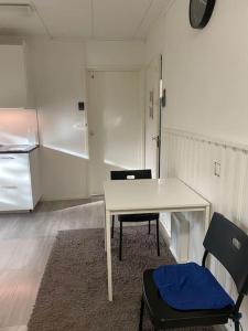 Zimmer mit einem Tisch, 2 Stühlen und einem Kühlschrank in der Unterkunft Kotimaailma, Hostel Kivikkotie (room 6) in Vantaa