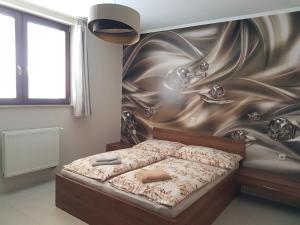a bedroom with a bed with a wall mural at Vila Lexus in Veľký Meder