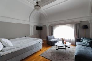 1 dormitorio con cama, sofá y mesa en Piteå Stadshotell en Piteå