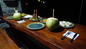 a wooden table with plates of food on it at Wahwik's House in Ubud