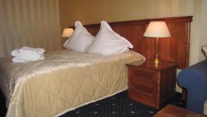 a hotel room with a bed with white pillows at Vila Codrin Neptun-Olimp in Neptun