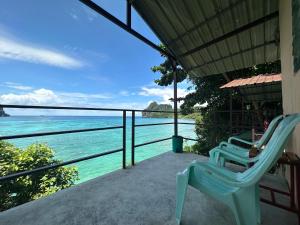 a chair sitting on a porch overlooking the ocean at Phi Phi Seaside Bungalow in Phi Phi Don