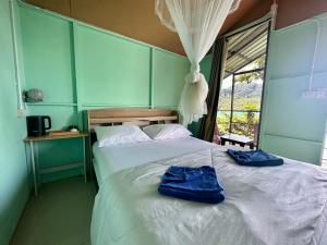 a bedroom with a bed with two blue towels on it at Phi Phi Seaside Bungalow in Phi Phi Don