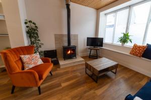 un soggiorno con camino e sedia di 4 Connaught Street Birr a Birr Altre 2 foto
