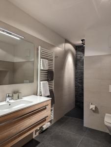 y baño con lavabo y espejo. en ARLhome Lodge - Zuhause am Arlberg en Sankt Anton am Arlberg