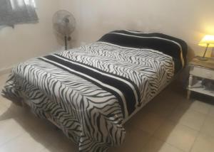 a bed with a black and white comforter in a room at Casa REYES JUJUY in Reyes