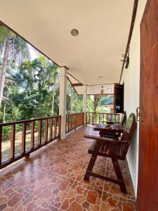 a room with a balcony with a wooden table at Jungle house in Baan Tai