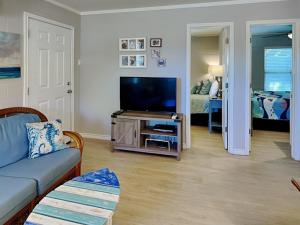 a living room with a couch and a flat screen tv at Harbor Lights Cottages 3 in Rockport