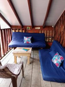 a room with a blue couch and a table at La Cabaña posada turística in Buenaventura