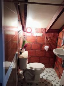a bathroom with a toilet and a sink at La Cabaña posada turística in Buenaventura