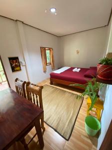 a bedroom with a bed and a table in a room at Jungle house in Baan Tai