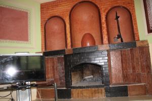 una chimenea de ladrillo con TV en una habitación en hotel evasion en Marrakech