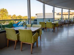 een eetkamer met tafels en stoelen op een balkon bij Bodrum Beach Resort in Gümbet