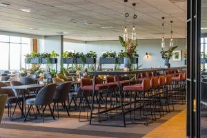 a restaurant with tables and chairs and a bar at Postillion Utrecht Bunnik in Bunnik
