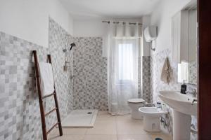y baño con ducha, aseo y lavamanos. en Casa Martina en Giugliano in Campania